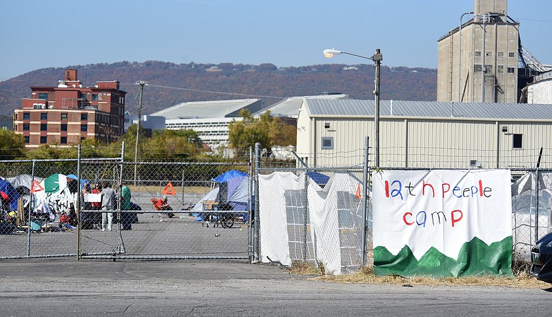 Staff Photo by Matt Hamilton / Tents line an asphalt lot at the homeless camp at the intersection of 12th Street and Peeples Street on Oct. 28.