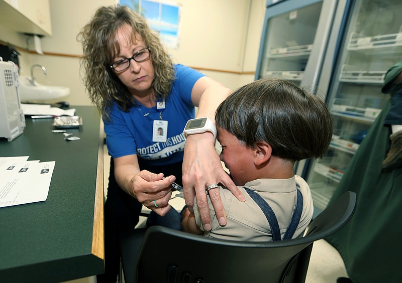 AP File Photo/Paul Vernon / A registered nurse and immunization outreach coordinator with the Knox County Health Department administers a vaccination to a child at the facility in Mount Vernon, Ohio, on May 17, 2019.