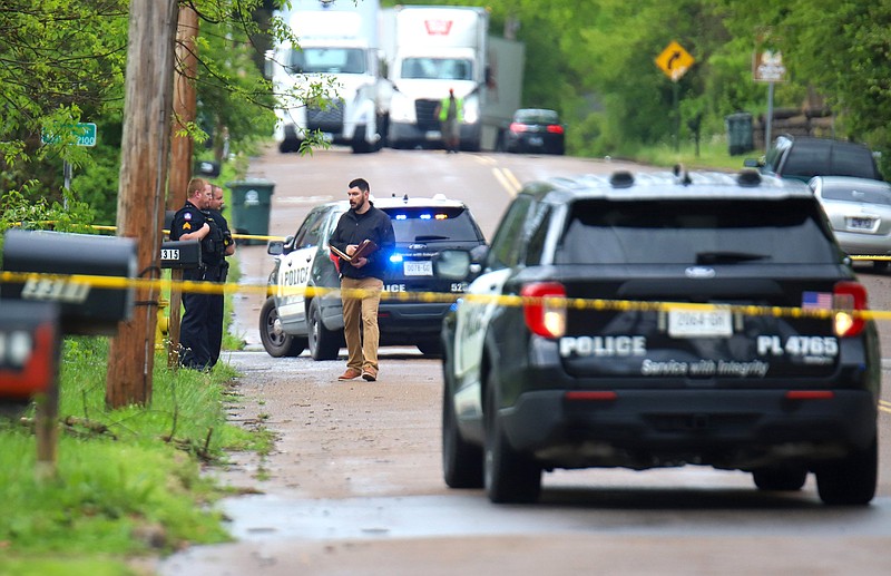 Staff Photo by Olivia Ross / An investigator speaks with officers. Police tape of an area of the 3300 block of Dodson Avenue following a shooting April 14.