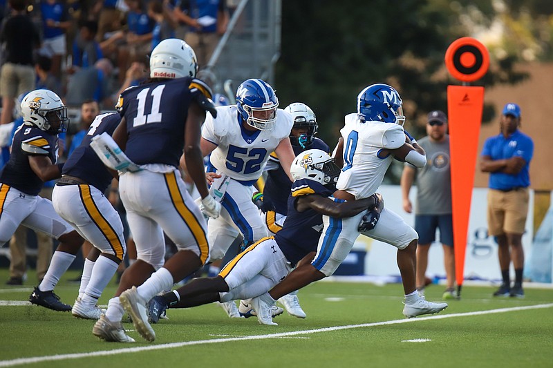 Staff photo by Olivia Ross / McCallies JaVon McMahan carries the ball as Chattanooga Christian's Ezra Duble works to bring him down Friday night in the season opener for both teams. McMahan finished with 96 yards and three touchdowns on 12 carries to help the Blue Tornado to a 53-13 victory.