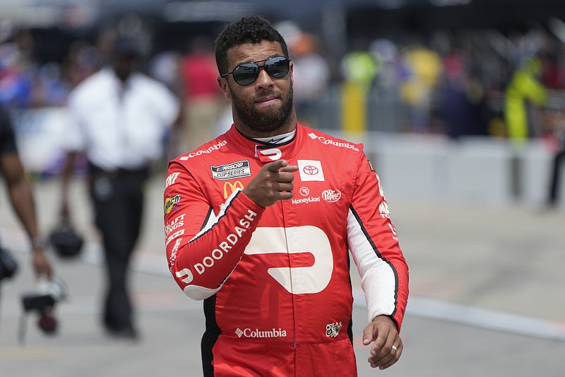 Bubba Wallace walks to his car during qualifications for a NASCAR Cup Series auto race at Michigan International Speedway in Brooklyn, Mich., Saturday, Aug. 5, 2023. (AP Photo/Paul Sancya)