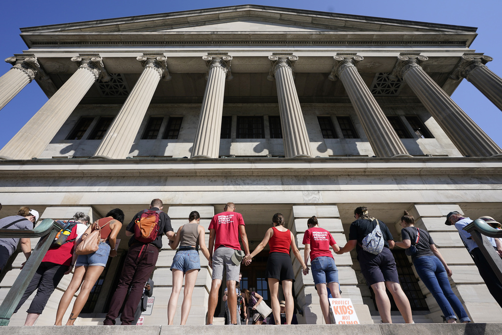 Demonstrators hold hands and encircle the State Capitol in prayer before a special session of the state legislature on public safety Monday, Aug. 21, 2023, in Nashville, Tenn. (AP Photo/George Walker IV)