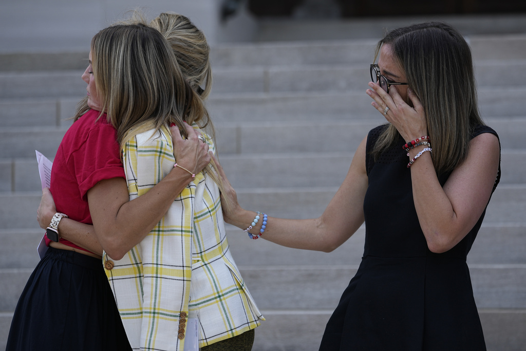 Covenant School parents Mary Joyce, left, Melissa Alexander and Sarah Shoop Neumann, right, comfort each other on the steps of the State Capitol during a Covenant Families Action Fund news conference before a special session of the state legislature on public safety Monday, Aug. 21, 2023, in Nashville, Tenn. (AP Photo/George Walker IV)