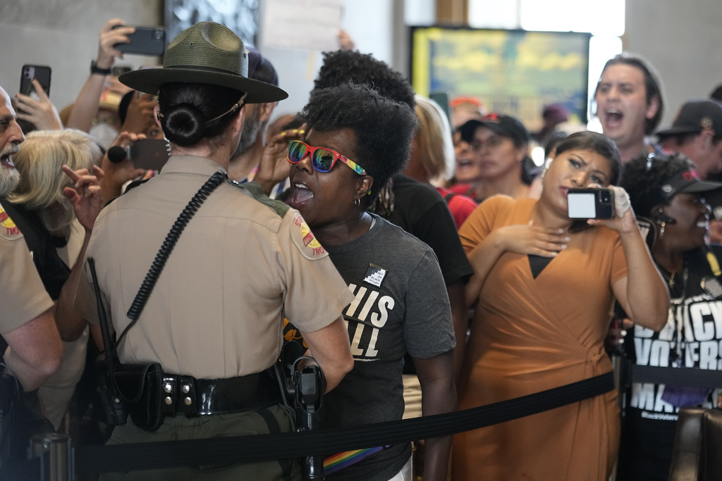A demonstrator yells in a State Trooper's face in the lobby of the State Capitol during a special session of the state legislature Monday, Aug. 21, 2023, in Nashville, Tenn. (AP Photo/George Walker IV)