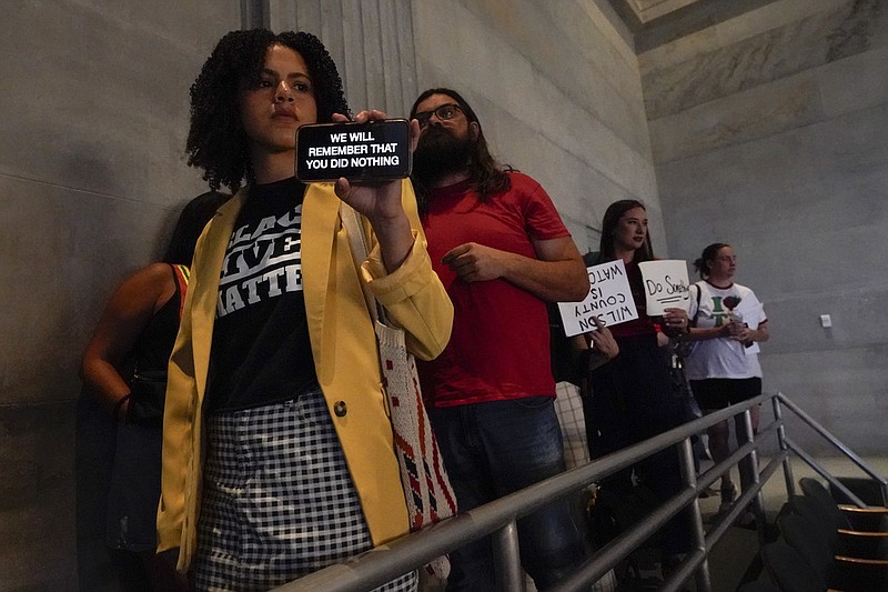 People hold signs as they leave the Senate chamber after a special session of the state legislature on public safety Thursday, Aug. 24, 2023, in Nashville, Tenn. (AP Photo/George Walker IV)