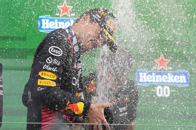 AP photo by Peter Djeong / Red Bull driver Max Verstappen sprays champagne on the podium after winning Formula One's Dutch Grand Prix on Sunday in the Netherlands. Verstappen's ninth straight win ties the F1 record held by Sebastian Vettel.