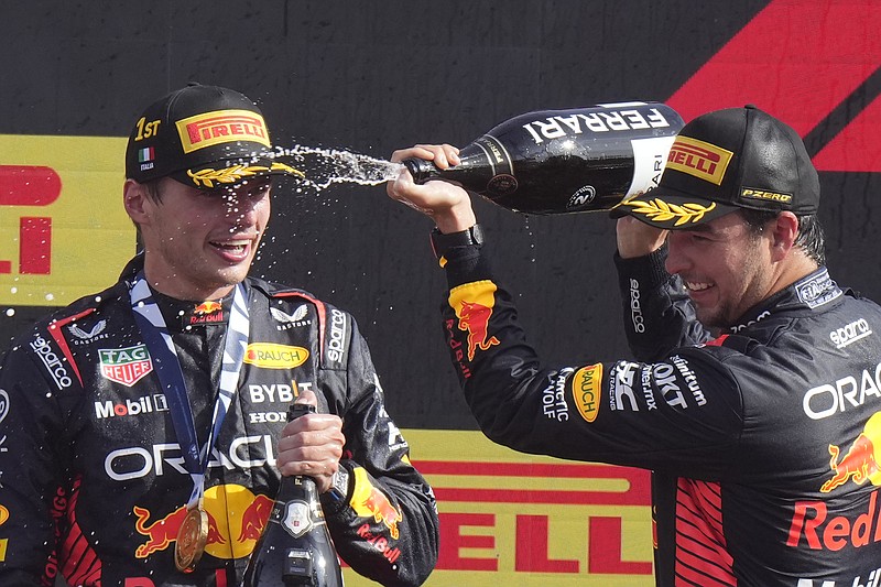 AP photo by Luca Bruno / Red Bull teammates Sergio Perez, right, and Max Verstappen celebrate after Formula One's Italian Grand Prix on Sunday in Monza. Verstappen won for the 10th race in a row, setting an F1 record, and Perez finished second in a dominant showing for their team.