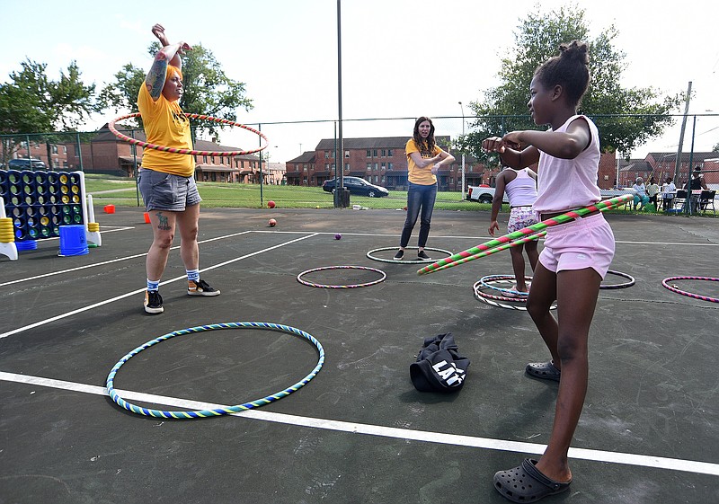 Staff Photo by Matt Hamilton / Aubrey Henriksen, left, Hula-Hoops with Ken'zhia Phillips, 9, right, in 2021 at College Hill Courts. The area has been identified for redevelopment.