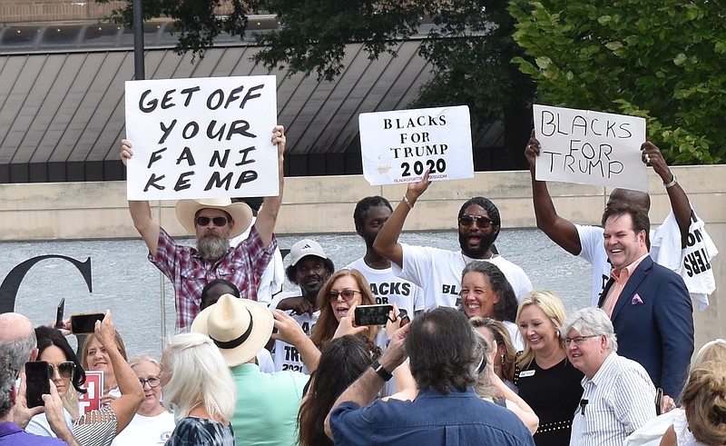 Staff Photo by Andrew Wilkins / Attendees of an Atlanta rally for a special legislative session to investigate Fulton County District Attorney Fani Willis hold signs Sept. 7.