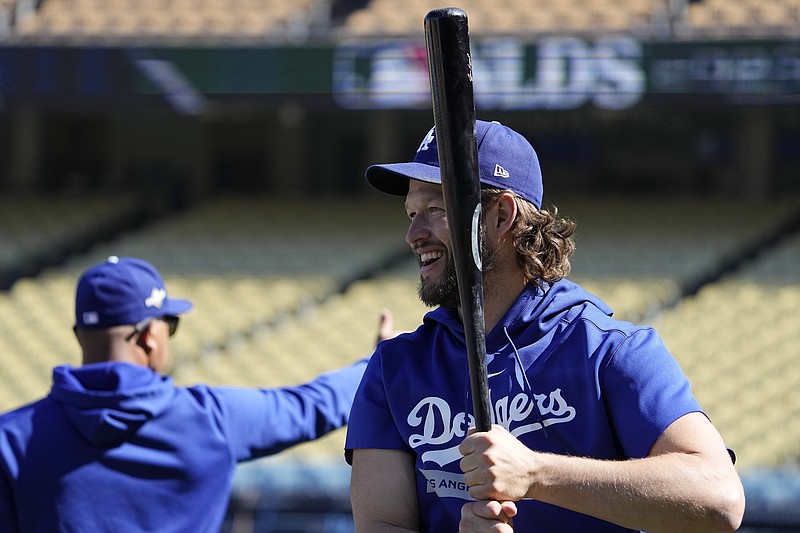 AP photo by Mark J. Terrill / Los Angeles Dodgers pitcher Clayton Kershaw laughs as he grabs a bat and warms up during practice Friday ahead of an NL Division Series against the Arizona Diamondbacks.