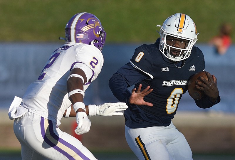 Staff photo by Matt Hamilton / UTC running back Ailym Ford carries the ball as Western Carolina's Rod Gattison defends during a SoCon game on Oct. 7 at Finley Stadium.