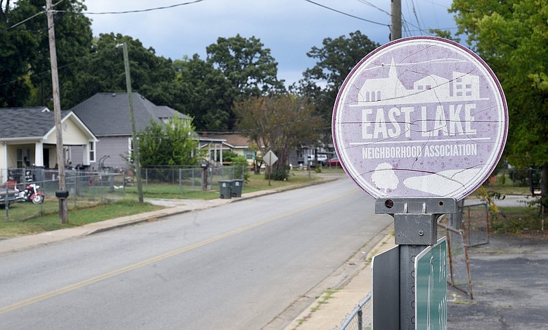 Staff photo by Matt Hamilton / An East Lake Neighborhood Association sign sits atop a street sign at the corner of Fourth Avenue and East 34th Street in the East Lake neighborhood Sept. 15.