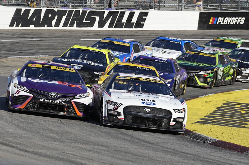 AP photo by Chuck Burton / Team Penske's Ryan Blaney, right, and Joe Gibbs Racing's Denny Hamlin battle as they lead the field out of the second turn during Sunday's NASCAR Cup Series playoff elimination race at Virginia's Martinsville Speedway.