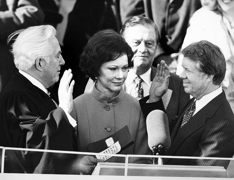 Photo by STRINGER/AFP via Getty Images/TNS / U.S. Supreme Court Chief Justice Warren Burger, left, administers the oath of office to Jimmy Carter, right, as the 39th president of the United States on Jan. 20, 1977, as Rosalynn Carter looks on.