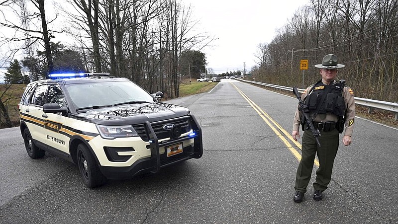 A Tennessee Highway Patrol trooper blocks the road to McGhee Tyson Air National Guard Base after reports of shots being fired in 2020, in Alcoa, Tenn. (AP Photo/Michael Patrick)