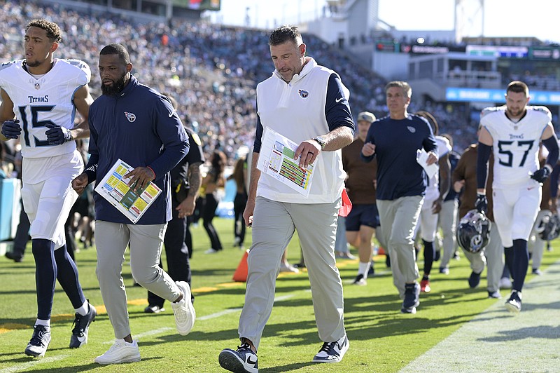 AP photo by Phelan M. Ebenhack / Tennessee Titans coach Mike Vrabel, center, leaves the field after the first half of last Sunday's game against the host Jacksonville Jaguars.