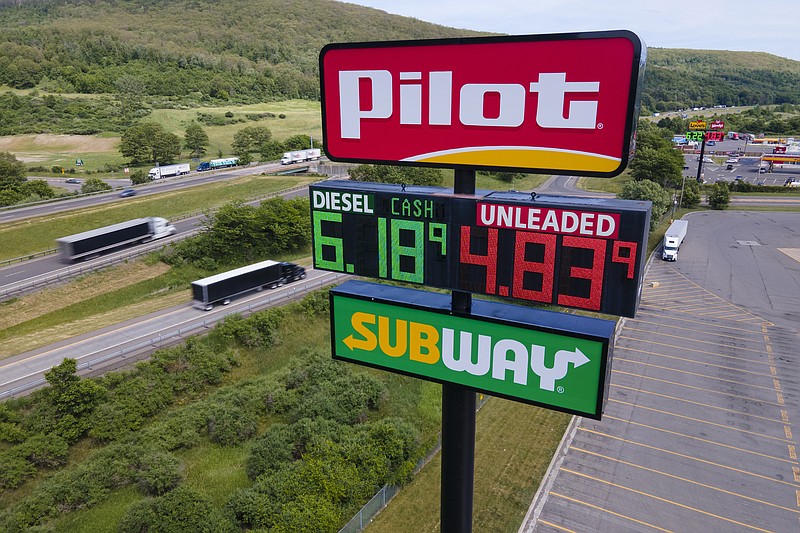 FILE - Trucks and cars drive by a Pilot Travel Center sign displaying fuel prices in Bath, New York, on Monday, June 20, 2022. Warren Buffetts Berkshire Hathaway says the billionaire Haslam family tried to bribe at least 15 executives at the Pilot truck stop chain with millions of dollars to inflate the companys profits this year because that would force Berkshire to pay more for the Haslams remaining 20% stake in the company. (AP Photo/Ted Shaffrey, File)