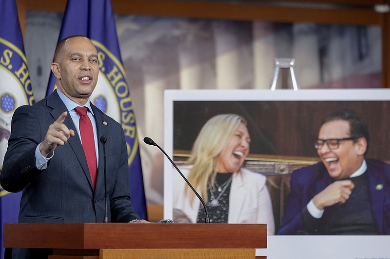 House Minority Leader Hakeem Jeffries, D-N.Y., speaks during his weekly news conference on Capitol Hill, Thursday, Nov. 30, 2023, in Washington, next to a photo of Rep. George Santos, R-N.Y., and Rep. Marjorie Taylor Greene, R-Ga., sitting in the House chamber together and laughing. (AP Photo/Mariam Zuhaib)