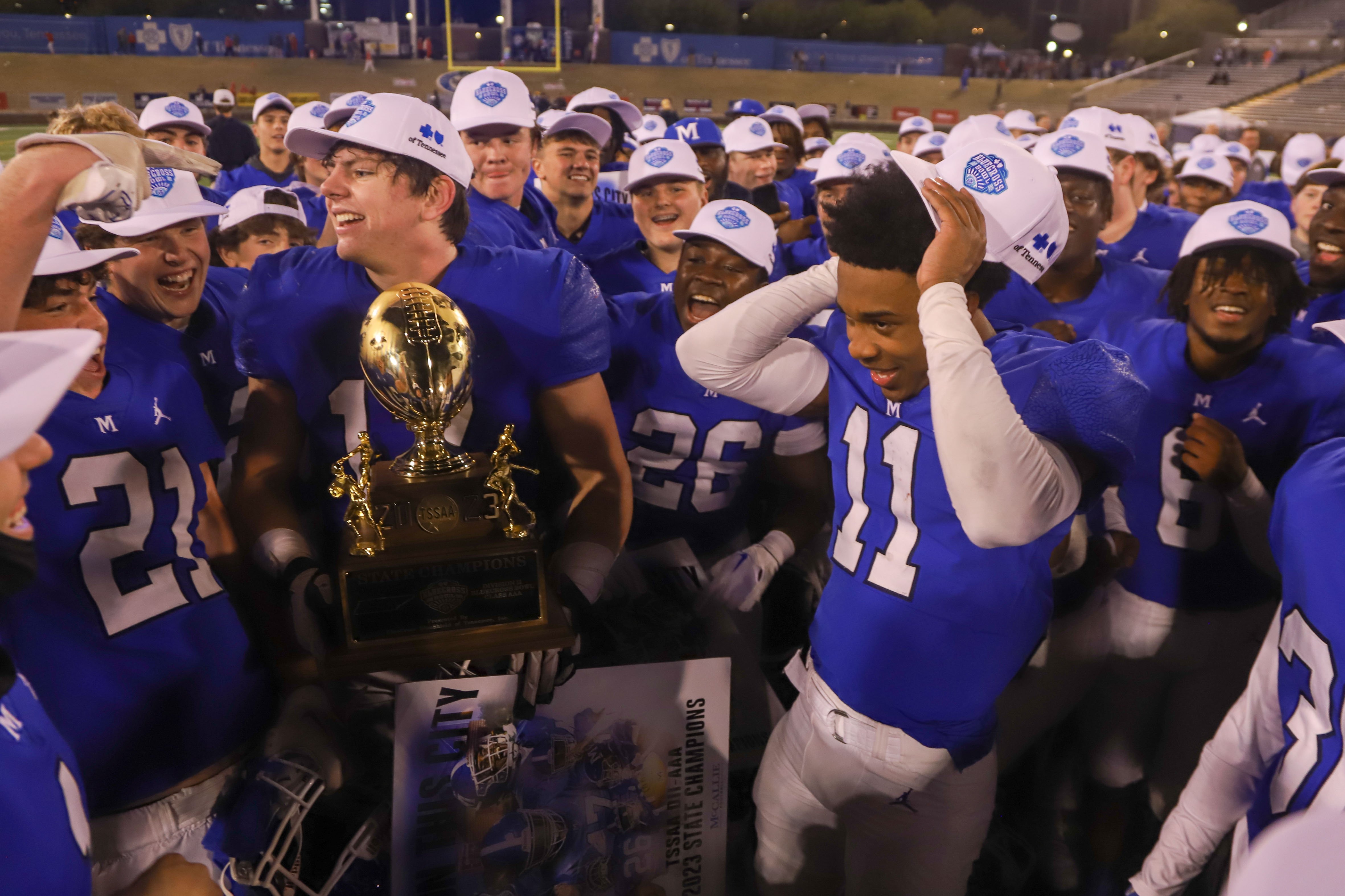Staff photo by Olivia Ross / McCallies Carson Gentle (17) holds the trophy, the team celebrates after their win against Baylor. Baylor took on McCallie on Thursday, November 30, 2023 in the BlueCross Bowl Division II-AAA state championship game at Finley Stadium.