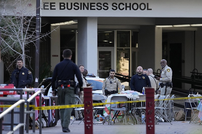 (AP Photo/John Locher) Las Vegas police stand near the scene of a shooting at the University of Nevada, Las Vegas, Thursday, Dec. 7, 2023, in Las Vegas. Terrified students and professors cowered in classrooms and dorms as a gunman roamed the floors of a campus building on Wednesday, killing several people and critically wounding another person before dying in a shootout with police.