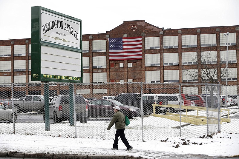 AP photo by Mike Groll / A man walks past the Remington Arms Company in January 2013 in Ilion, N.Y. The gun factory in upstate New York with a history stretching back to the 19th century is scheduled to close in March 2024, according to a letter from the company to union officials last month.