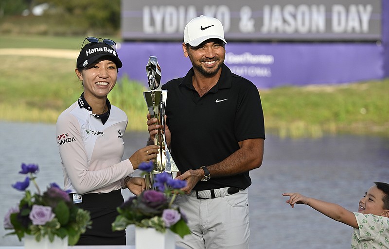AP photo by Steve Nesius / LPGA player Lydia Ko and PGA Tour member Jason Day hold the championship trophy on Sunday after winning the Grant Thornton Invitational, the first mixed-team event for the two tours since 1999.