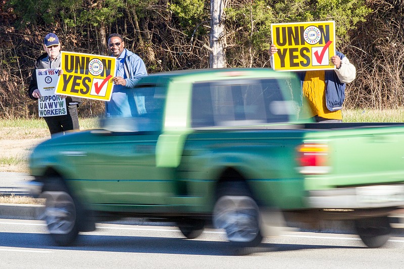 Union supporters hold up signs near the Volkswagen plant in Chattanooga, Tenn., on Friday, Dec. 4, 2015. Skilled-trades workers at the plant were voting on whether to be represented by the United Auto Workers for collective bargaining purposes. (AP Photo/Erik Schelzig)