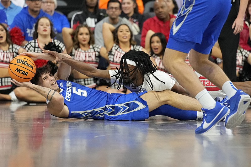 AP photo by John Locher / Creighton guard Francisco Farabello (5) prepares to pass from the floor as UNLV forward Keylan Boone reaches for the ball during the first half of Wednesday night's game in Henderson, Nev.