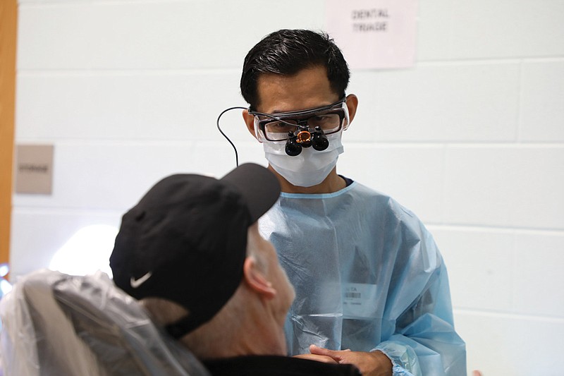 Contributed photography / Dr. An Ta checks a patient in dental triage at a RAM clinic in Cleveland, Tennessee, in November 2022. The patient had not been to a dentist since 1978.