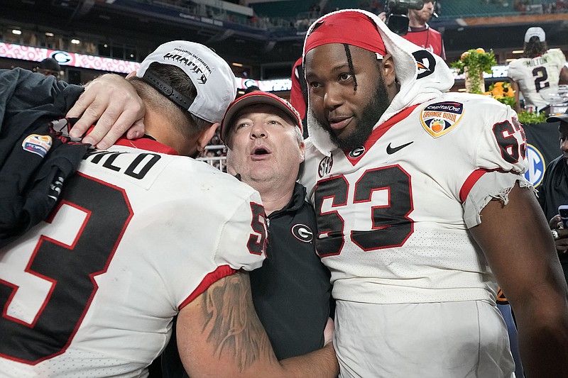 AP photo by Lynne Sladky / Georgia football coach Kirby Smart, center, hugs offensive linemen Dylan Fairchild, left, and Sedrick Van Pran after the Bulldogs' 63-3 Orange Bowl victory against Florida State on Dec. 30 in Miami Gardens, Fla.