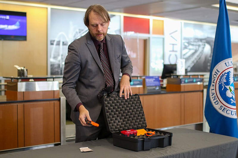 Staff Photo by Olivia Ross / Mark Howell with Transportation Security Administration demonstrates how to correctly pack guns for air travel in May 2022. All firearms must be unloaded, stored in a locked container and declared.