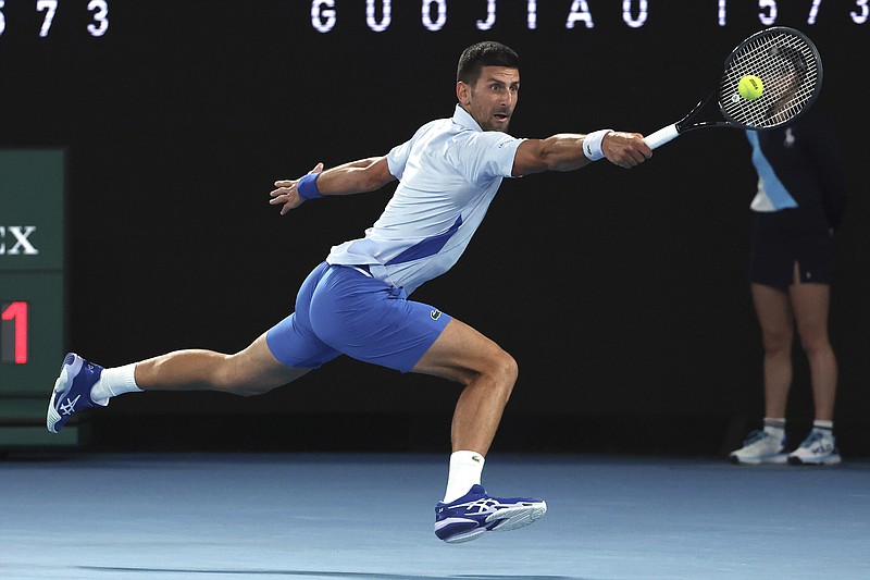 AP photo by Asanka Brendon Ratnayake / Novak Djokovic stretches out as he races to make a backhand return to Adrian Mannarino during their fourth-round match Sunday at the Australian Open.