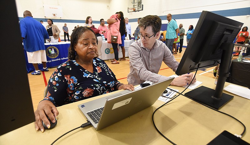 Staff photo by Matt Hamilton / Tim Moreland, with the city of Chattanooga, talks to Lena Ellis as she beta tests an affordable housing search tool during an affordable housing fair at the Glenwood Community Center in June. The issue is a top concern in a new Health Department survey.