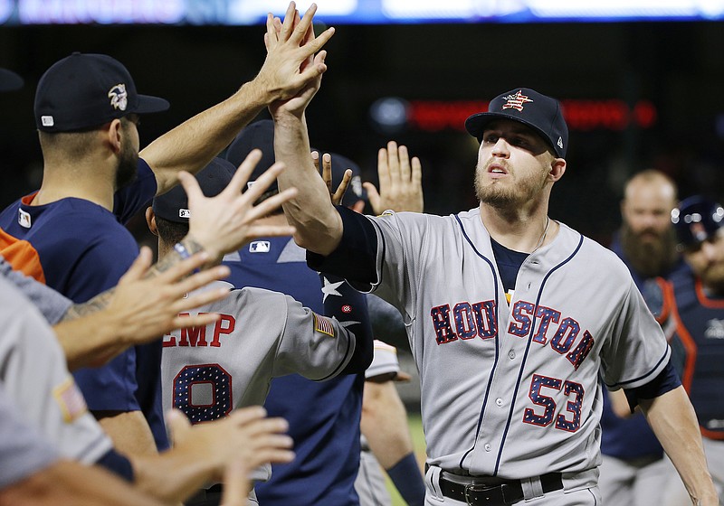 AP photo by Brandon Wade / Houston Astros relief pitcher Ken Giles (53) is congratulated by teammates after the team's 10-inning win against the host Texas Rangers on July 4, 2018.