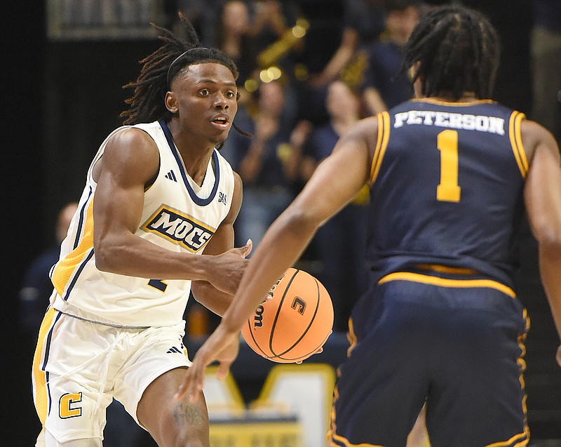 Staff photo by Matt Hamilton / UTC's Trey Bonham, left, looks for an open teammate while guarded by East Tennessee State's Quimari Peterson during Wednesday night's game between SoCon rivals at McKenzie Arena.