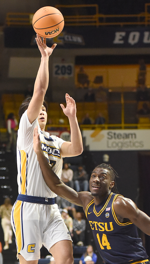 Staff photo by Matt Hamilton/ ETSU (14) Ebby Asamoah defends as UTC (77) Myles Che puts up a shot during their game at McKenzie Arena on Wednesday, February 14, 2024.