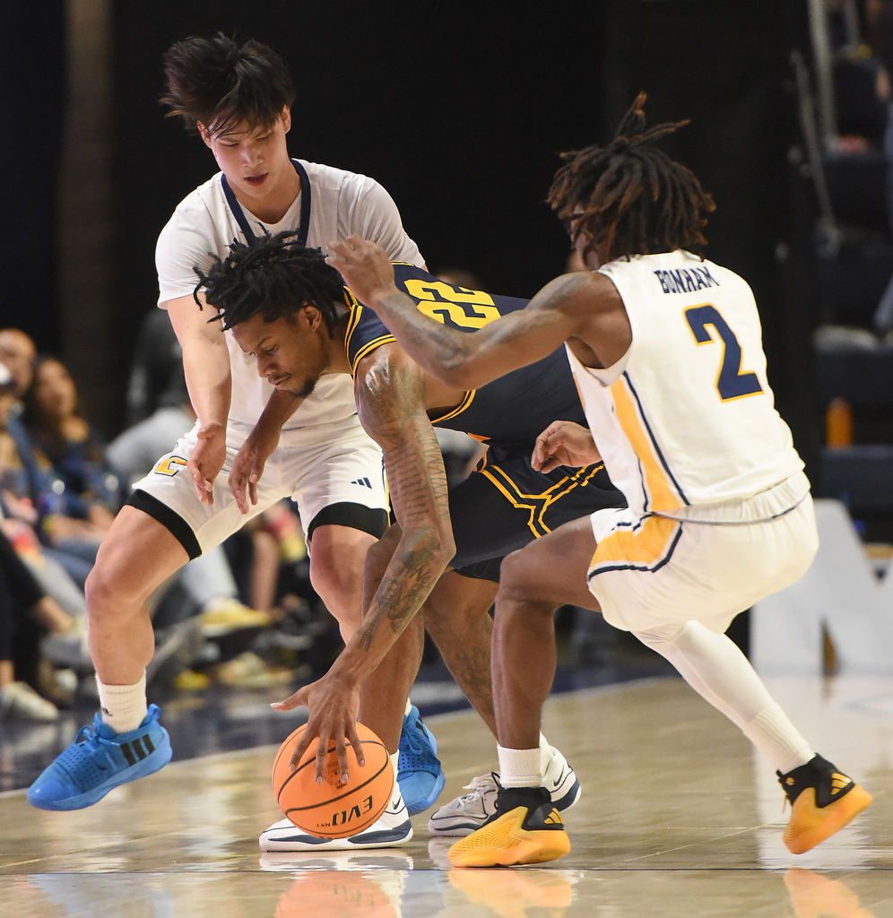 Staff photo by Matt Hamilton/ ETSU (22) Jayden Seymour has trouble controlling the ball as UTC (77) Myles Che and (2) Trey Bonham apply pressure during their game at McKenzie Arena on Wednesday, February 14, 2024.