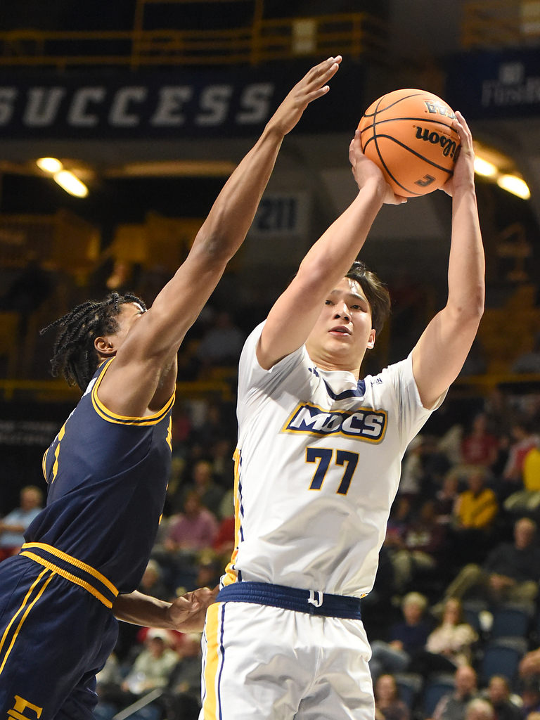 Staff photo by Matt Hamilton/ ETSU (1) Quimari Peterson defends as UTC (77) Myles Che puts up a shot during their game at McKenzie Arena on Wednesday, February 14, 2024.