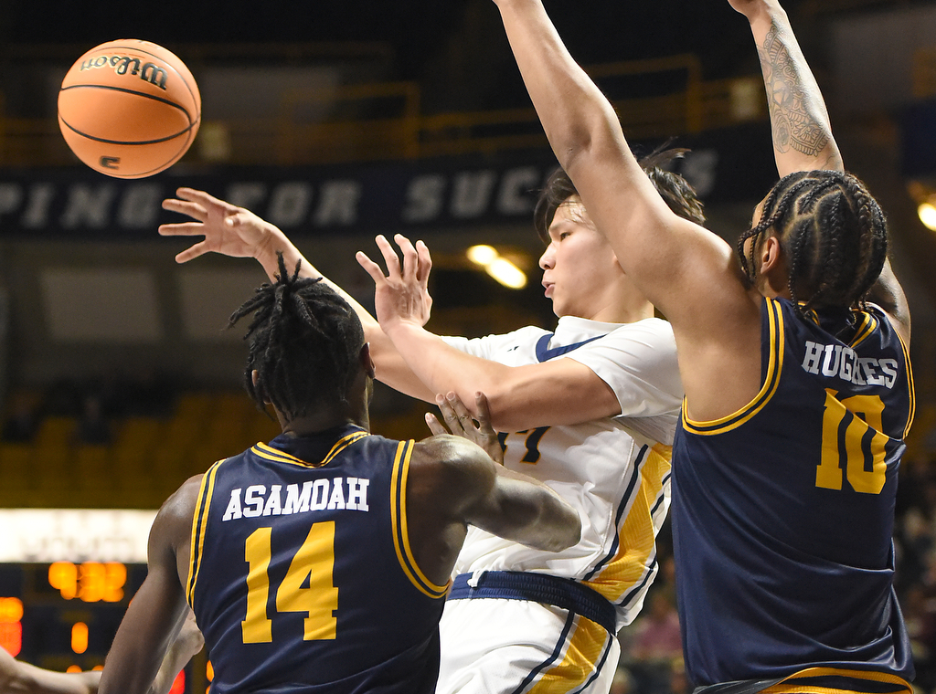 Staff photo by Matt Hamilton/ As UTC (77) Myles Che encounters the ETSU defense, he passes the ball to a teammate during their game at McKenzie Arena on Wednesday, February 14, 2024.