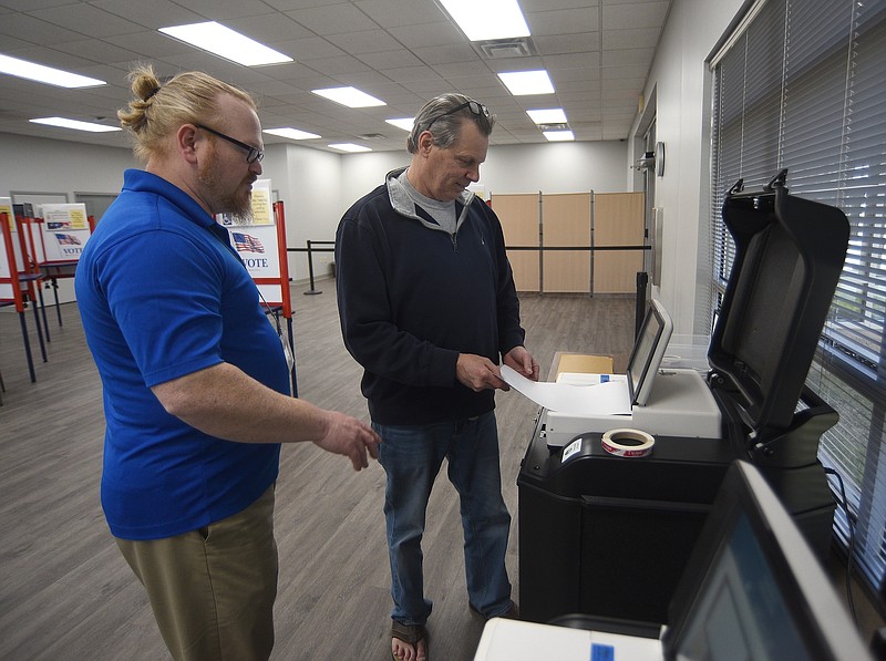 Staff photo by Matt Hamilton/ Frank Gibson, left, helps Chattanooga resident Peter Hawkins record his ballot at the Hamilton County Election Commission on Feb.  15.