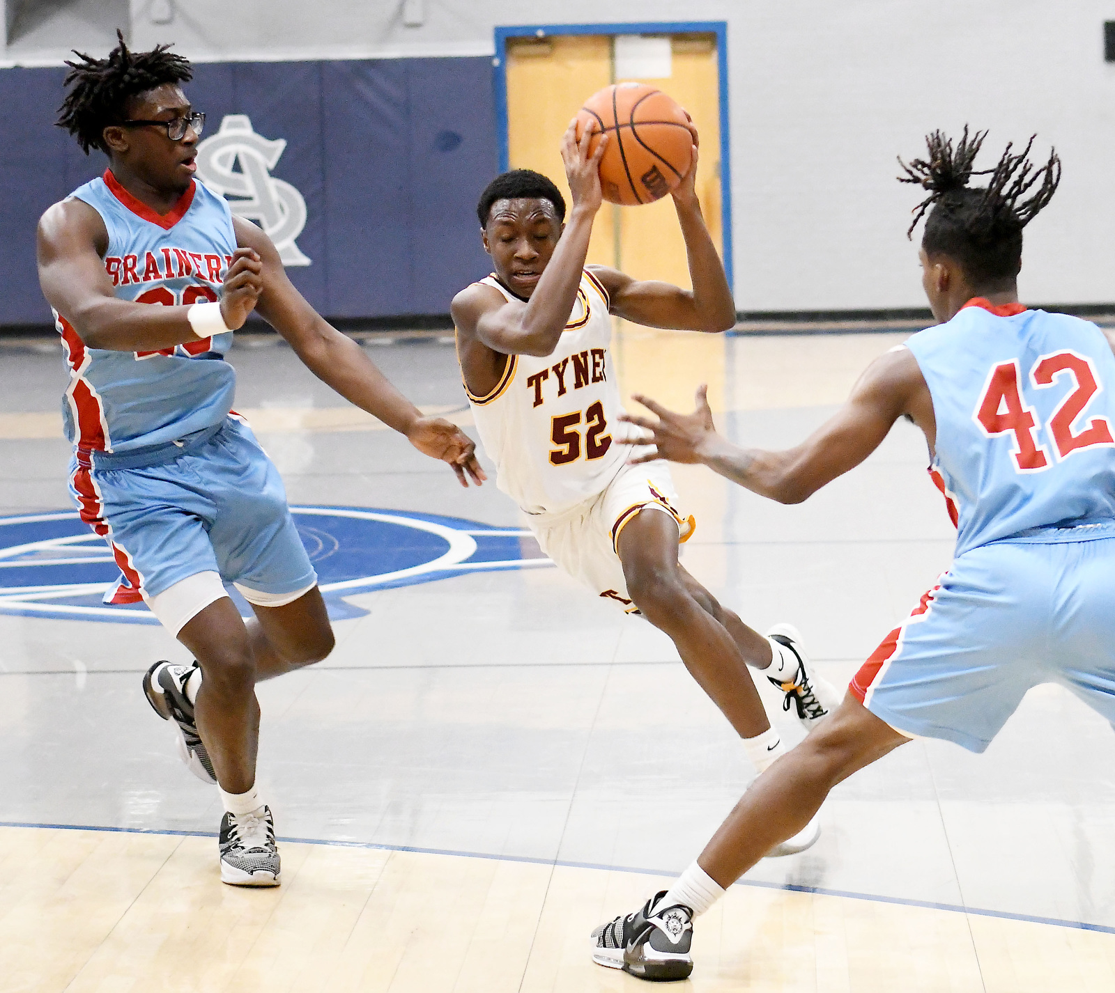 Staff Photo by Robin Rudd / Tyner's Kohl Ward (52) drives between two Panthers. The Brainerd Panthers met the Tyner Rams in the District 4-AA tournament championship, played at Chattanooga School for Arts and Sciences, on February 20, 2024.