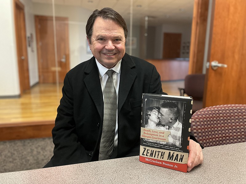 Staff photo by Mark Kennedy / During an interview Thursday, attorney McCracken Poston shows his new book, "Zenith Man," which is about a 1999 North Georgia murder trial.