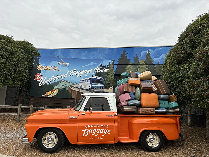 Staff photo by Emily Crisman / Hugo, an orange truck named after the founder of Unclaimed Baggage, is loaded with luggage and parked in front of the Scottsboro, Alabama, store.
