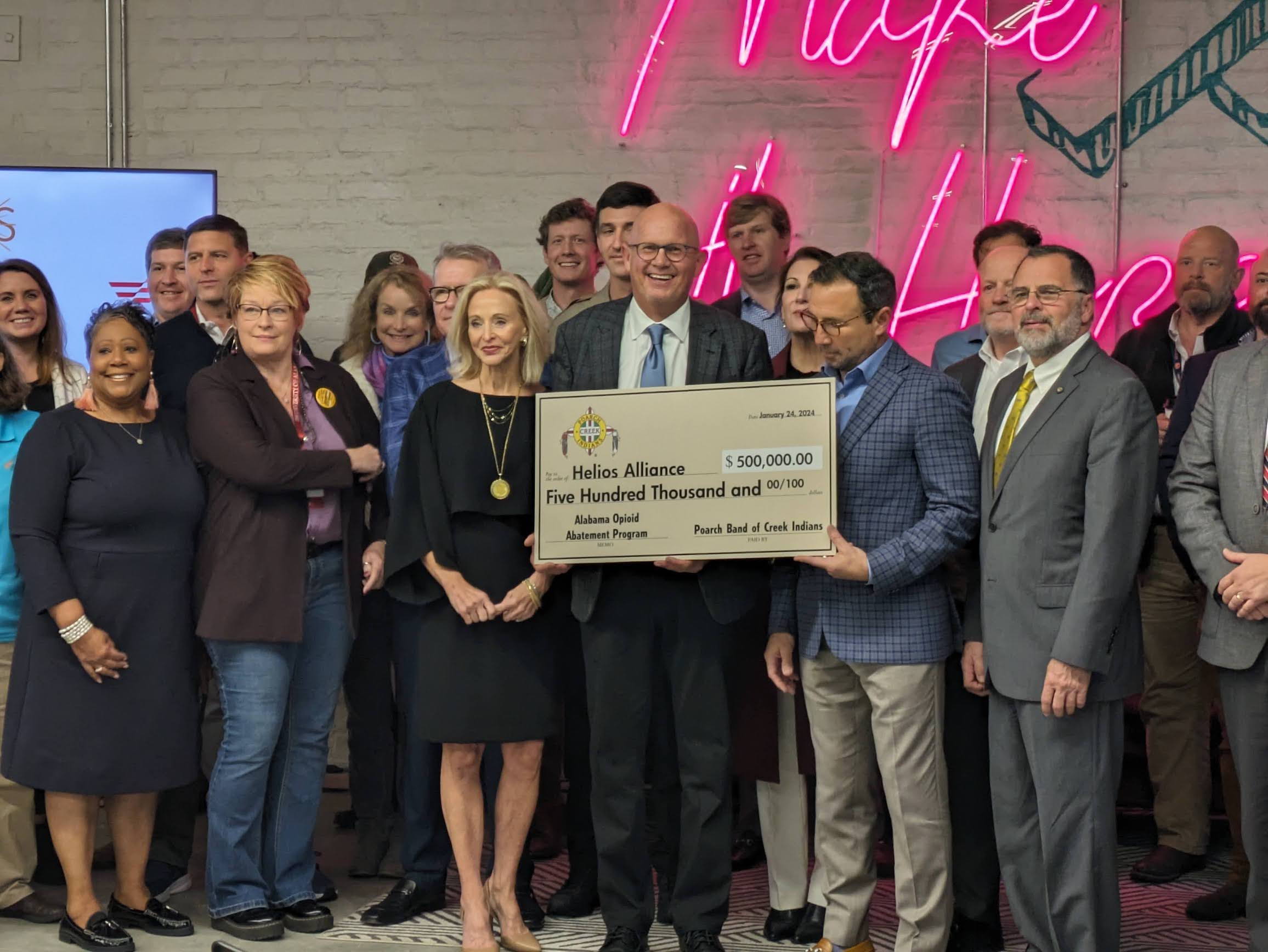 At an event Jan. 24 in downtown Mobile, Ala., the Poarch Band of Creek Indians presented a check for $500,000 from the tribe's opioid settlement funds to the Helios Alliance, a group of statistical modelers, media strategists, consultants and artificial intelligence experts. The alliance plans to use the money to build a model it says can help Alabama leaders decide how to spend the rest of their opioid settlement funds. (Aneri Pattani/KFF Health News)