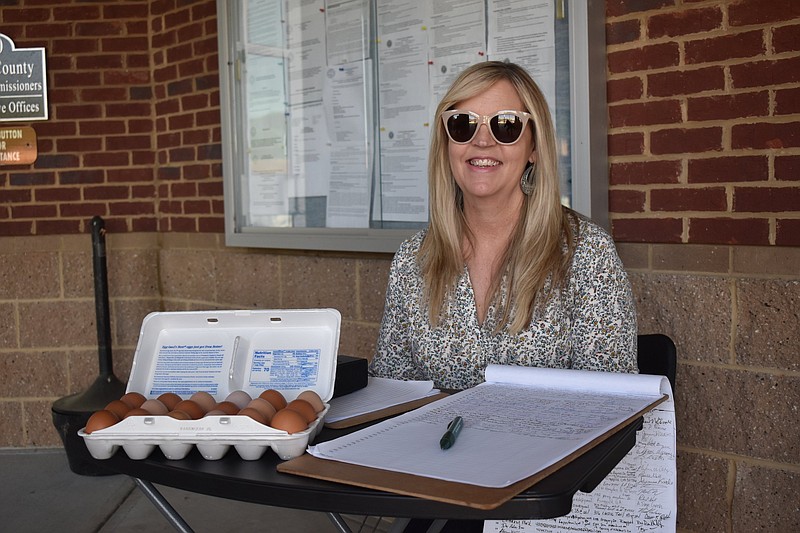 Staff Photo by Andrew Wilkins / Joanna Hildreth sits April 19 with a container of backyard chicken eggs and a petition requesting a loosening of Catoosa County's property code to allow items like gardens, sheds, children's play equipment and storm and bomb shelters. Hildreth is chair of the Catoosa County Republican Party.