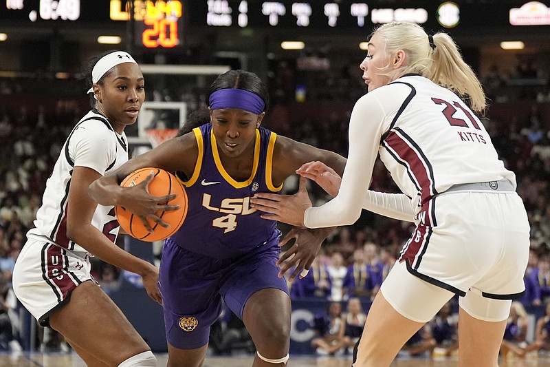 AP photo by Chris Carlson / LSU's Flau'jae Johnson drives to the basket between South Carolina guard Bree Hall, left, and forward Chloe Kitts during the SEC tournament title game Sunday in Greenville, S.C.