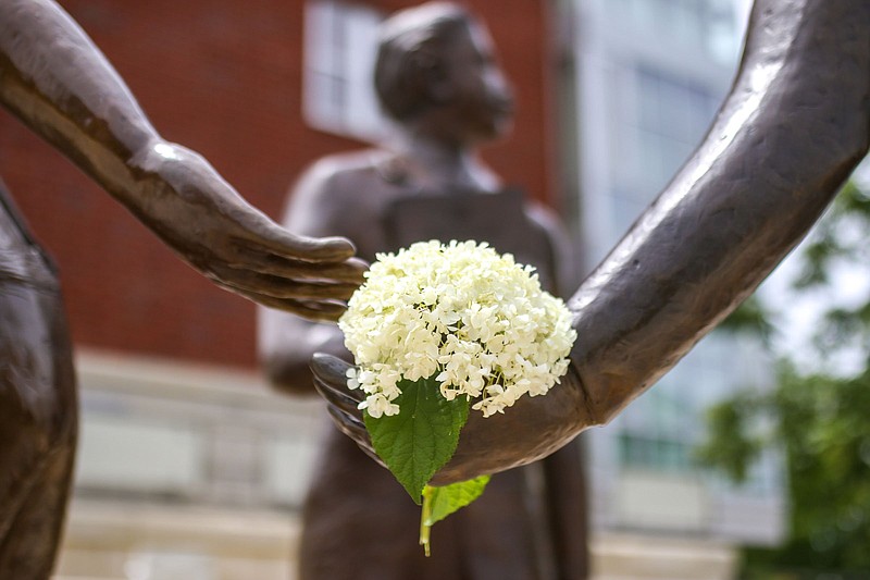 Staff file photo by Olivia Ross  / Flowers adorn the Ed Johnson Memorial on June 10, 2022. A commemoration of the wrongful lynching of Johnson on the Walnut Street Bridge in 1906 will be held March 19.