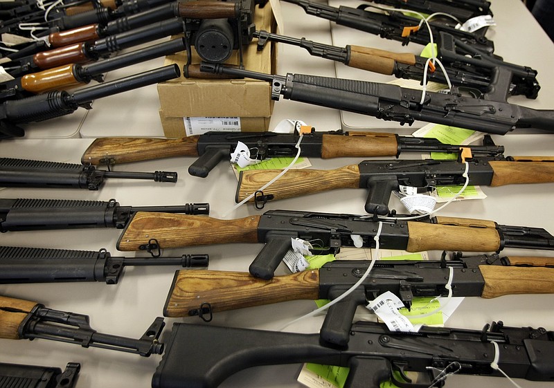 File photo/Matt York/The Associated Press / In this Jan. 25, 2011, file photo, a cache of seized weapons that were to be smuggled into Mexico is displayed in Phoenix, Ariz. Gun-control advocates and some experts say the violence that immigrants are fleeing is carried out by American guns that are smuggled over the border.