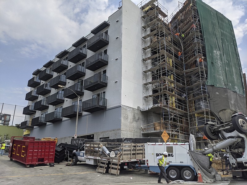 File photo/Damian Dovarganes/The Associated Press / In this June 18, 2021, photo, construction workers finish the exterior of an apartment building downtown Los Angeles. California Gov. Gavin Newsom September 2021, approved two measures to slice through local zoning ordinances as the most populous state struggles with soaring home prices, an affordable housing shortage and stubborn homelessness.