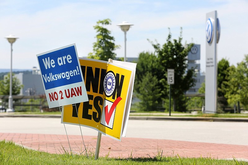 Staff file photo / Signs for and against the union drive in 2019 are shown in a roundabout along Volkswagen Drive in front of the Volkswagen production plant in Chattanooga. The UAW lost the election.